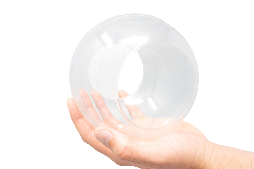 hand holding large glass globe terrarium with two open ends