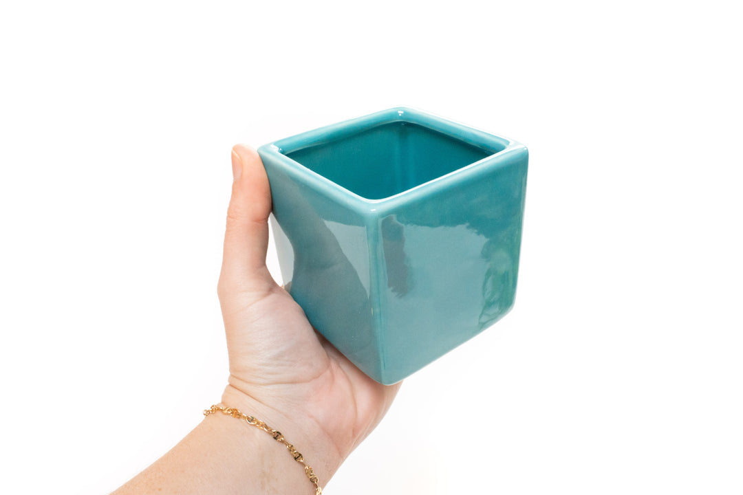 hand holding blue ceramic cube container