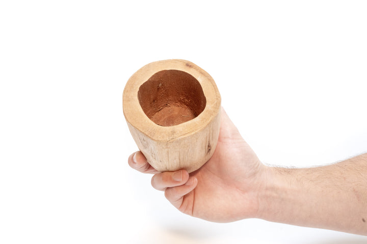 hand holding a driftwood container, tilted so opening is showing