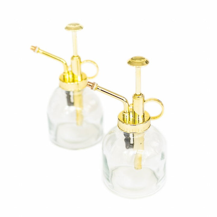 two glass misters with gold colored spray nozzle